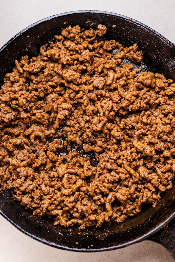 This a photo of seasoned ground beef in a black pan.