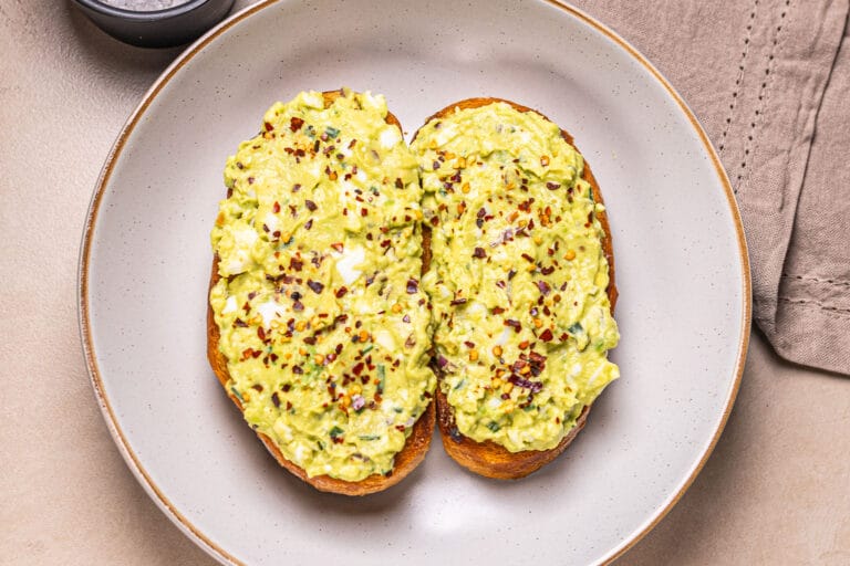 This is a photo of smashed avocado on toast in a plate