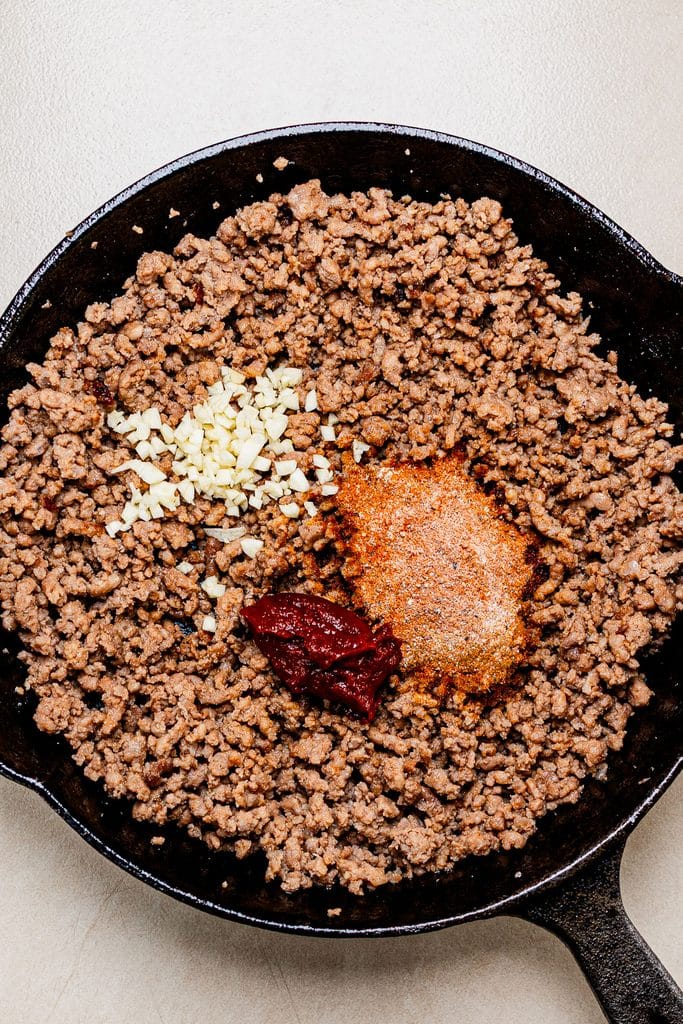 This is a photo of browned ground beef topped with spice, garlic, tomato paste.