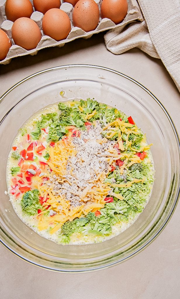 Eggs with cottage cheese topped with broccoli, cheddar cheese, cottage cheese, red peepper and spice.
