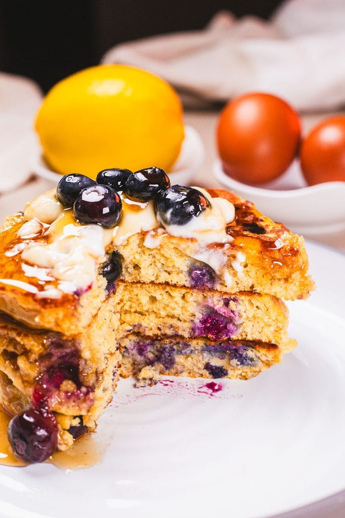 Fluffy high protein blueberry pancakes made with Greek yogurt, oat flour, and eggs, topped with fresh blueberries for an easy breakfast.