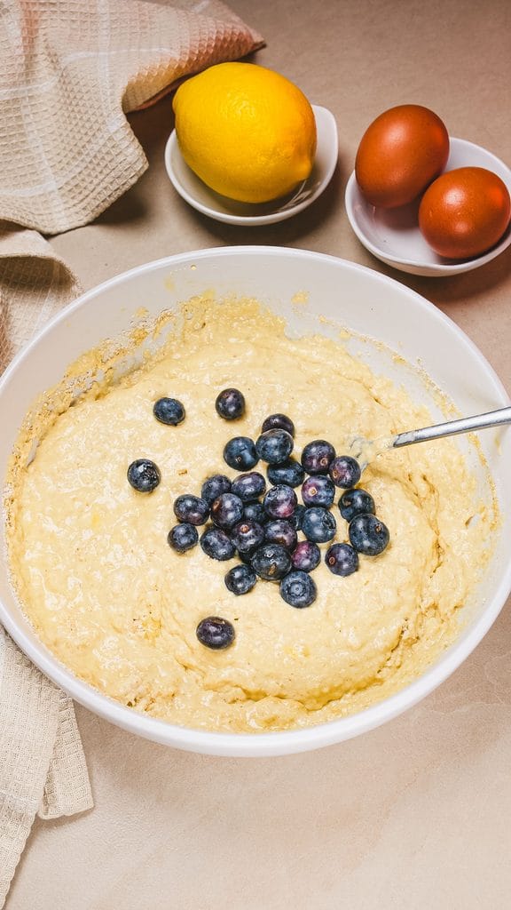 Thick homemade blueberry pancake batter with fresh blueberries folded in, ready to cook.